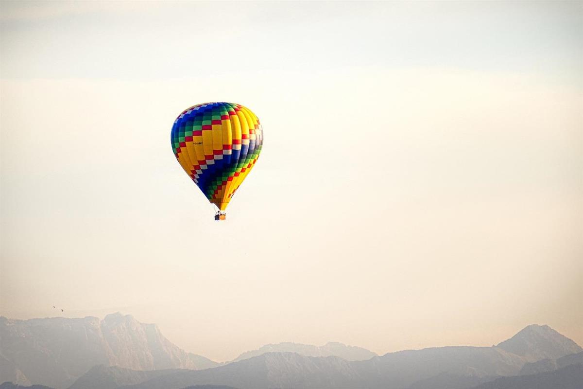 luftballong som svever høyt over fjell - Klikk for stort bilde